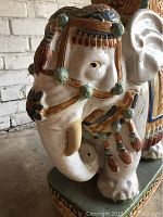 Close-up of the elephant plant stand's head showing detailed glaze and ornamental features.