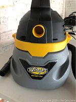 Front view showing Stinger logo, air outlet, and compact design of the wet/dry vacuum.