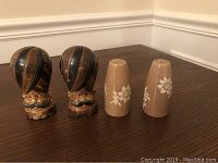 Pair of ceramic beige salt and pepper shakers with white floral patterns, simpler design