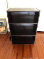 Full view of the black bookshelf showing adjustable shelves and overall structure.