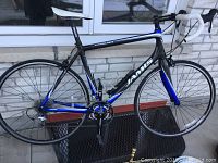 Left side view of full Jamis Endura road bike showing black and blue carbon fiber frame, drop handlebars, wheels and pedals