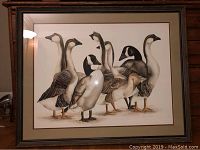Framed watercolor painting depicting various waterfowl including geese and ducks clustered together.