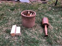 Traditional wood carving set displayed outdoors including large mallet, twelve carving tools, and two practice wood blocks.