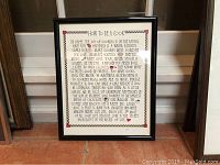 Framed kitchen art print titled "How To Be A Cook" displayed upright against a wall with a radiator behind it.