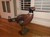 Front view of the vintage carved wooden bird showing colors, shape, base, and beak condition.