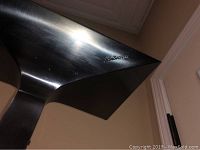 Close-up photo of the lamp's metal top reflector showing signed brand 'New Society'.