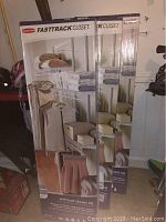 Photo showing three unopened Rubbermaid FastTrack Closet kits in their retail packaging, standing upright.