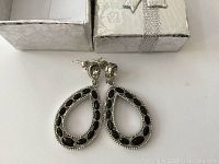 Photo of front side of the silver tone earrings with black stones with gift box
