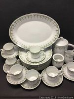 Full view of partial Noritake Forest Glen Nitto Ware 29 piece set showing cups, saucers, plates, teapot, sugar bowl (missing lid), creamer, and serving platter with green tree patterned design