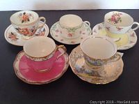 Photo showing all five sets of vintage English porcelain cups and saucers arranged in two rows, highlighting varied floral and decorative designs.