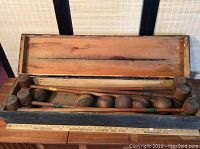Full view of the open wooden box containing six-piece antique wooden croquet set.