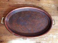 Top view of oval large walnut serving tray showing patina and metal handles