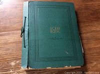 Front view of green scrapbook with gold 'SCRAP BOOK' lettering and textured cover.