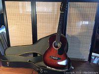 Hondo acoustic guitar in open hard case showing guitar body and case interior