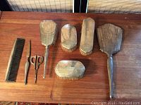 Full dresser set laid out showing all six pieces: two hand mirrors, three brushes, comb, scissors, and nail file.