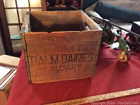 Front side view showing Palm Dairies Calgary stencil on the wooden crate.