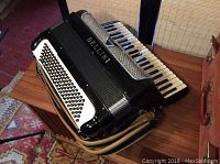 Side-front view of black Bellini accordion resting on wooden surface