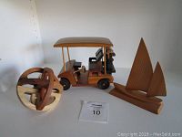 Three wooden items: golf cart model, 3D wooden puzzle, and sailboat model displayed on a light background.