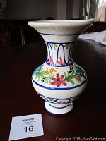 Full view of ceramic vase with floral pattern on wood table