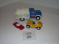 Overview of three toy vehicles: Tonka Pepsi truck, yellow Tonka buggy, and red Hot Wheels car.