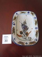 Front view of rectangular ceramic plate showing butterfly and floral hand-painted design with blue border and rusty colors.