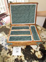 Open basket showing interior compartments lined with green floral fabric with white trim