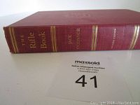 Side view of the book spine showing title, author, and edition details embossed in gold on red cloth.