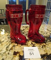 Two red translucent plastic beer boots on a granite countertop with MaxSold auction card number 51 visible.