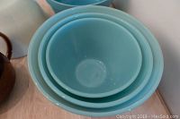 Top view of nested set of 3 light blue Fire King Blue Delphite splashproof bowls showing smooth glossy surfaces.