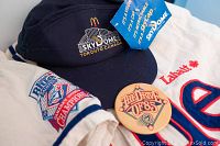 Close-up of navy blue retractable hat showing Skydome Toronto Canada logo and McDonald's logo with tag attached, placed on the jersey and pin