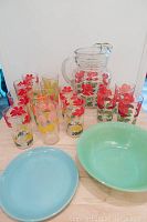 Full lot showing pitcher, juice glasses with floral prints, jadeite bowl and blue delphite plate.