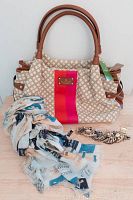 Kate Spade purse with scarf and bracelet laid on table