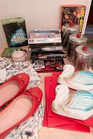 Overview photo with Kate Spade flats, vintage swan figurines, aluminum canisters, & stack of DVDs.