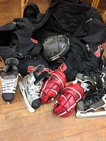 Full lot showing skates, gloves, helmet, and bag on floor