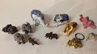 Full lot of 11 miniature elephant figurines showing variety of materials and sizes