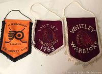 Three sports pennants displayed: Peterborough Pirates (orange) and two Whitley Warriors (maroon)