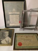 Four vintage framed items including photo, certificates, and empty frame