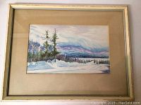 Framed watercolor painting showing an 18x14 inch winter landscape with trees, snow, and mountains.