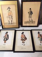 Overview photo showing all five framed prints side by side: two upright larger prints at the back and three smaller horizontal prints in front. The subjects are military figures in historical European or South American uniforms.