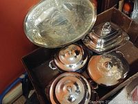 Silver plated serving set including tray, lidded round dishes, and stacked bowls.