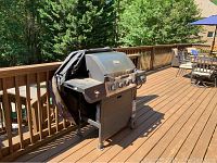 Side view of the Brinkman gas grill on the deck, showing wheels and prep shelf.