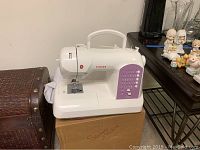 Singer Curvy sewing machine on box showing front and side views with stitch selection panel.