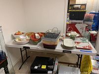 Wide angle of assortment showing bowls, plates, chip baskets, dishes, table cloths on white table