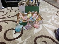 Box of several Josef Originals grow up figurines in pastel colors, some are broken; surrounded by packaging material