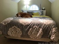 Full view of bed with white wooden headboard, showing approximate size and placement in bedroom.