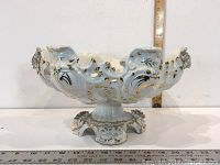 Side view of the ornate porcelain fruit bowl stand showing its height and decorative details