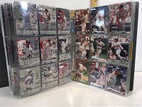 Close-up of one album page showing 18 baseball cards in plastic sleeves, featuring various MLB players in action and posed shots.