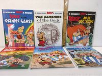 Front view of six Asterix comic books laid out, showing cover art and titles.