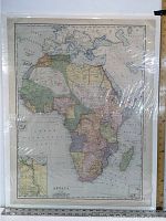 Full view of the antique map of Africa showing various colonial-era borders and regions, mounted with some plastic covering.