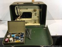 Full view of Bernina Minimatic sewing machine inside green carrying case with accessory box in front